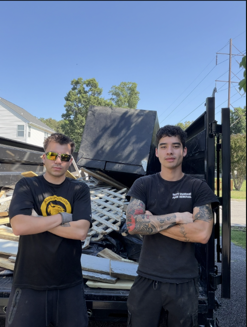 Waste Warriors crew beside a loaded junk removal trailer